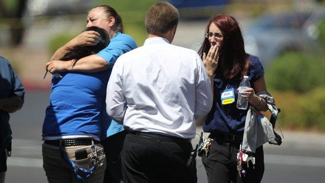 Walmart employees hug outside their store after shootings left five people dead