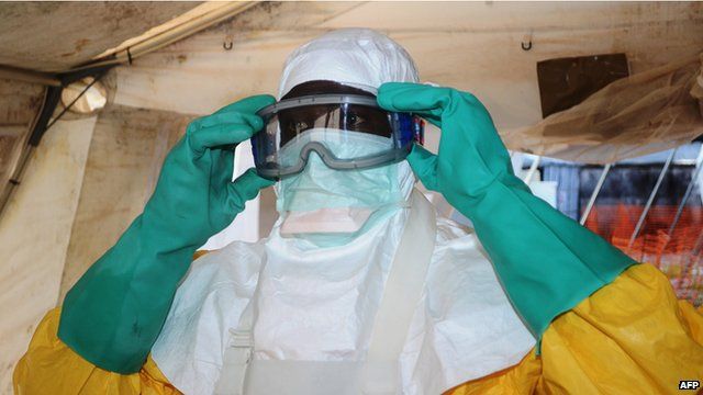 A medical worker puts on a mask