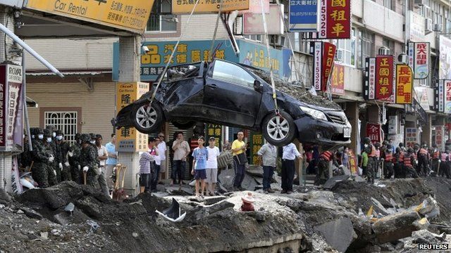 A damaged car is removed from the wreckage after an explosion in Kaohsiung