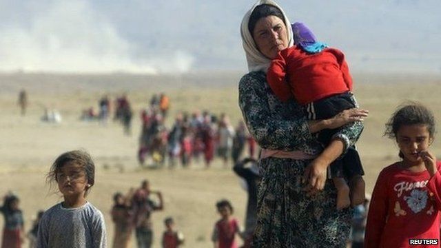 Displaced people from the minority Yazidi sect, fleeing violence from forces loyal to the Islamic State in Sinjar town, walk towards the Syrian border