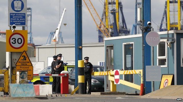 Policemen stand guard at an entrance to Tilbury Docks