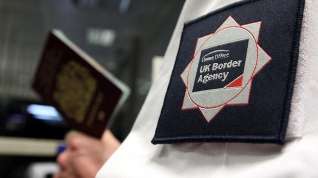 UK Border Agency man holding passport