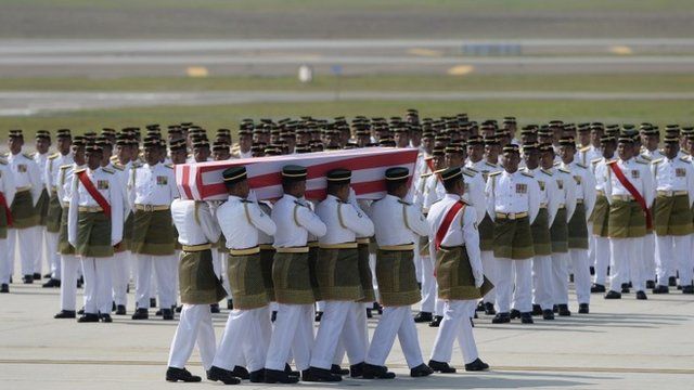 Coffins draped in the national flag were slowly carried to waiting hearses