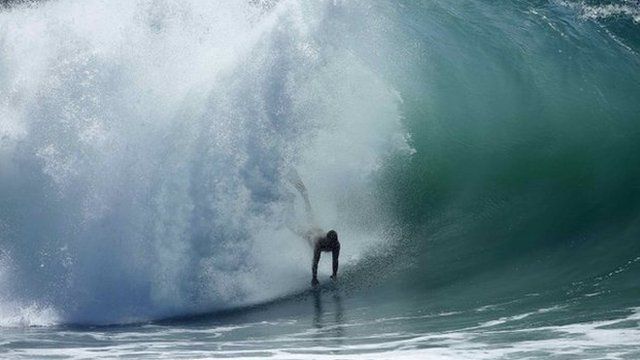 A swimmer catches a wave at "The Wedge" wave break in Newport Beach, California 27 August 2014