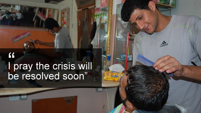 Barber Essam Habib serves a customer