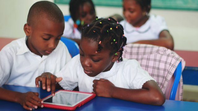 Students in the Ivory Coast looking at the Qelasy tablet in a classroom