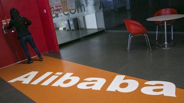 A woman stands next to a door inside the headquarters of Alibaba in Hangzhou, Zhejiang provinc