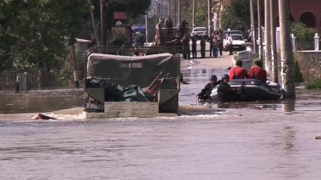 A truck tries to get through a flooded street