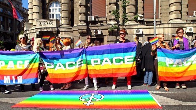 Gay rights activists holding a rainbow flag during a gay rights rally in downtown Belgrade
