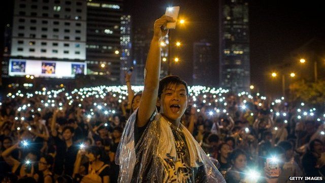Protesters waving illuminated mobile phones