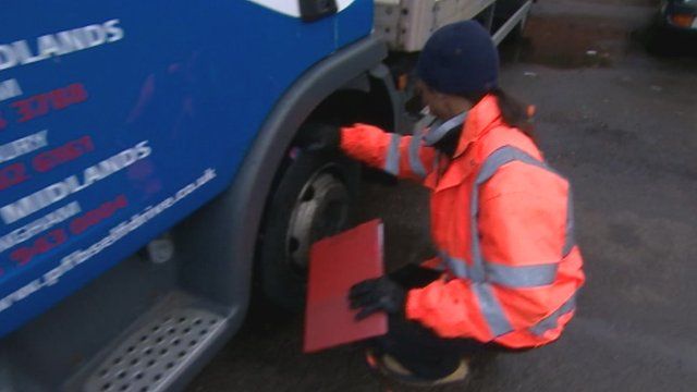 Man checking lorry tyre