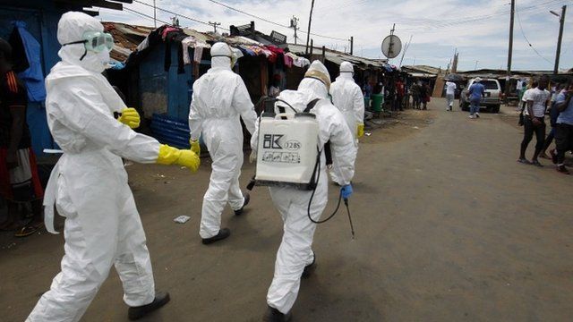 A Liberian Red Cross burial team on the move to pick up a suspected Ebola victim in the impoverished area of West Point, Monrovia, Liberia