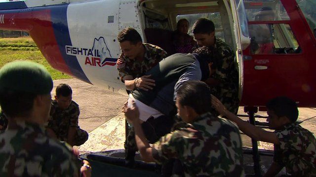 Soldiers helping a survivor out of a helicopter
