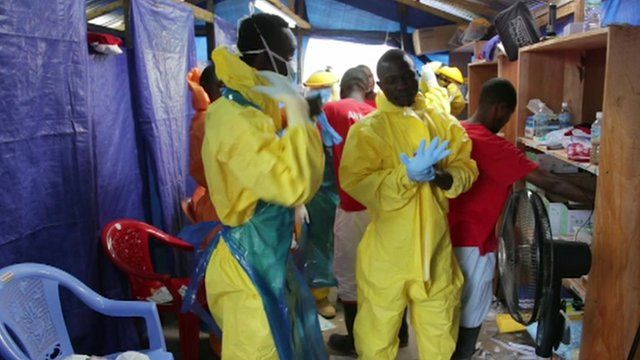 Healthcare workers putting on protective clothing