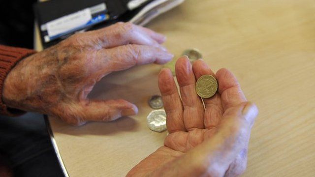 A pensioner holding coins
