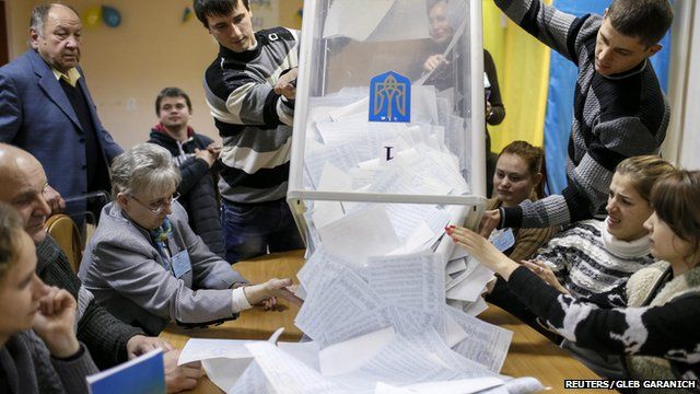 People tipping ballot papers out of a box ready for counting following Ukraine's parliamentary election on 26 October 2014