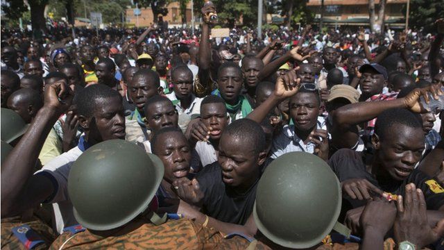 Anti-government protesters chant slogans in front of army headquarters in Ouagadougou