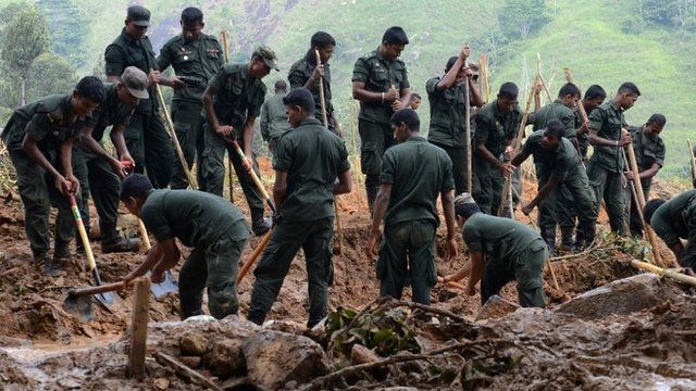 Sri Lankan military personnel dig during a search operation at the site of a landslide caused by heavy monsoon rains in Koslanda village in central Sri Lanka on November 1, 2014