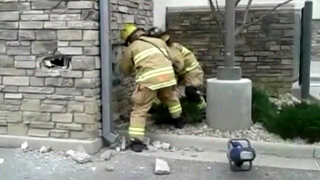 Fire fighters make hole in wall
