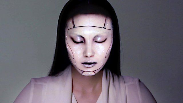 A model with a projection mapped onto her face