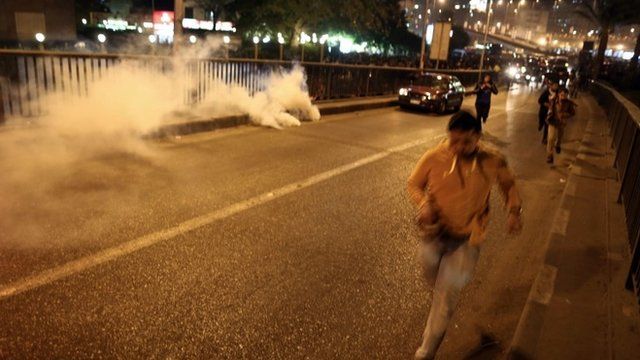 Anti-Mubarak protesters run from smoke grenades