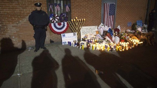 Candlelit vigil guarded by police for slain NYPD officers