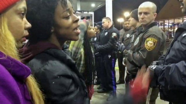 A frame grab from a video of locals arguing with police officers as they cordon off the site where a policeman allegedly shot a teenager at a gas station in Berkeley, St. Louis, Missouri