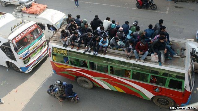 Nepalese people travel on bus roof tops as they leave Kathmandu fearing an epidemic or fresh tremers in Kalanki on the outskirts of Kathmandu