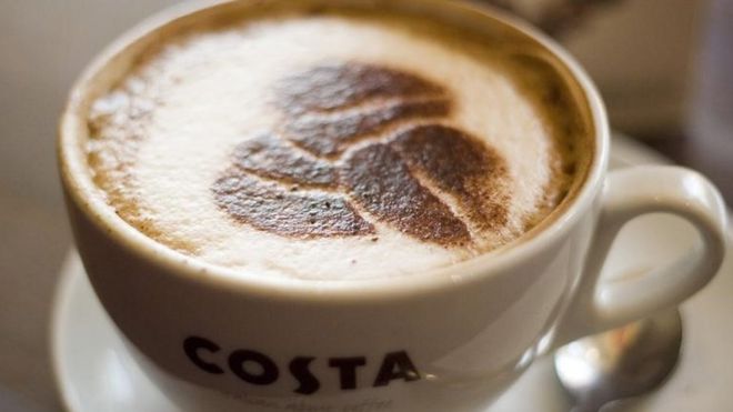 A Costa coffee cup with chocolate powder stencil of coffee beans