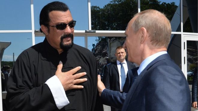 Russian President Vladimir Putin (R) speaks with US action movie actor Steven Seagal (L)