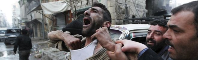 A father reacts after the death of two of his children by shellfire in the rebel-held al-Ansari area of Aleppo, Syria (3 January 2013)