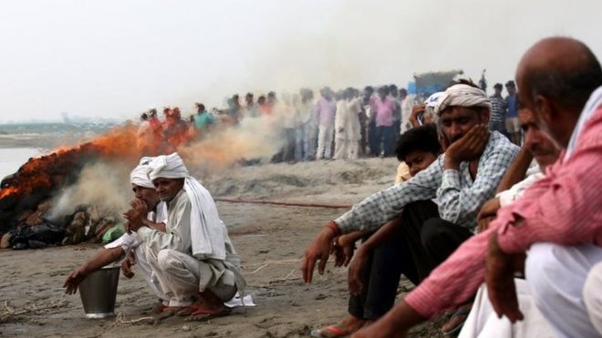 People cremate the bodies of the victims near the site where a riverboat capsized carrying 60 people in Baghpat, Uttar Pradesh, India, 14 September 2017.