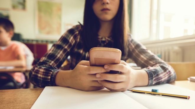 Schoolgirl using mobile phone, file pic