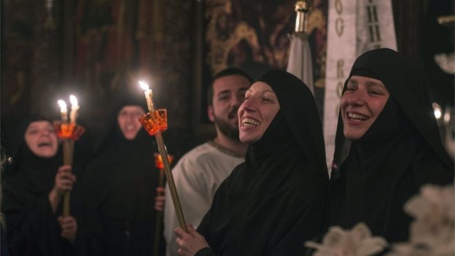 سيدات يضئن الشموع بكنيسة للمسيحيين الأرثوذكس في سكوبي بمقدونيا خلال احتفالات عيد الفصح