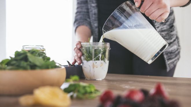 A man making a green smoothie