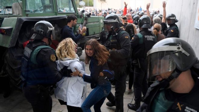 Women clash with Spanish Guardia Civil guards outside a polling station in Sarria de Ter, where Catalan president is supposed to vote, on 1 October 2017.