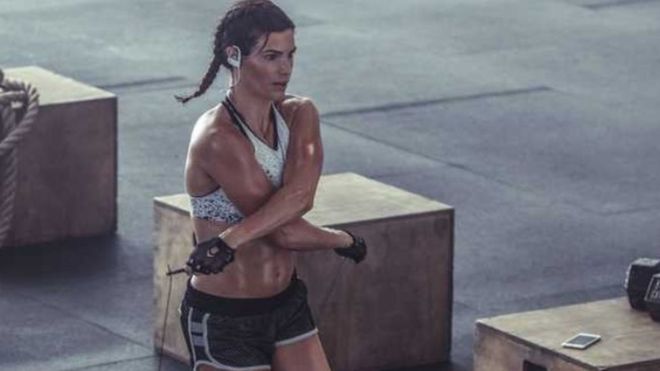 Advert for PowerBeats 3 from Beats website shows woman in gym