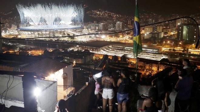 Habitantes de las favelas durante la inauguración ven el estadio Maracaná de lejos