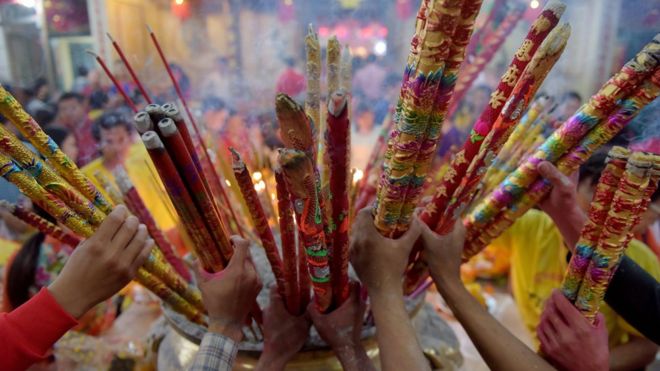 Cambodian-Chinese place various sizes of incense sticks into an urn at a temple to mark the start of the Lunar New Year in Kandal on February 16, 2018