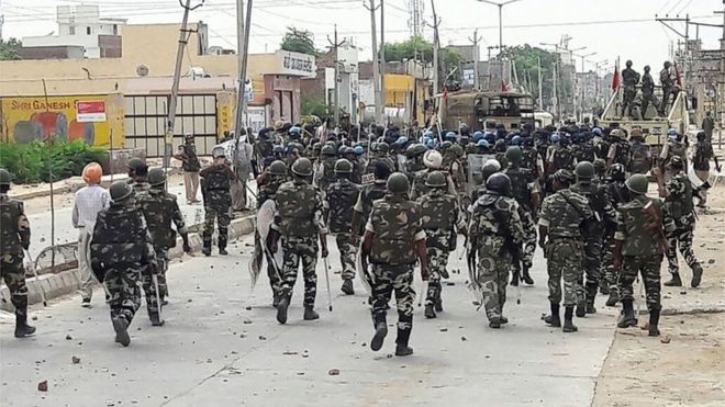 Indian paramilitary personnel walk towards the "Dera Sacha Sauda" Ashram in Sirsa on August 26, 2017, after followers of controversial guru Ram Rahim Singh on August 25 went on a rampage after their spiritual leader was convicted of rape.