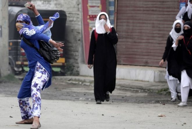 A Kashmiri female student throws a rock on police during clashes in Srinagar, the summer capital of Indian Kashmir, 24 April 2016