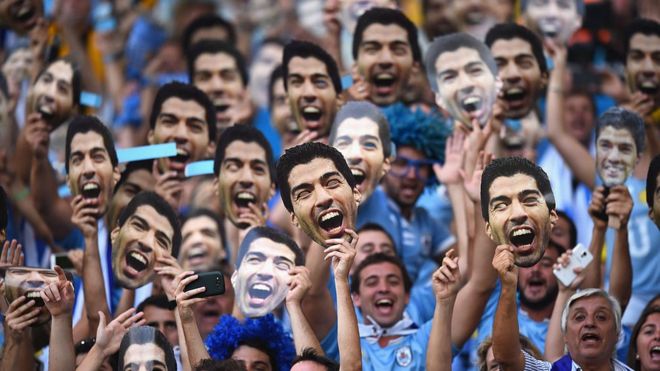 Uruguaios com máscadas de Suárez.