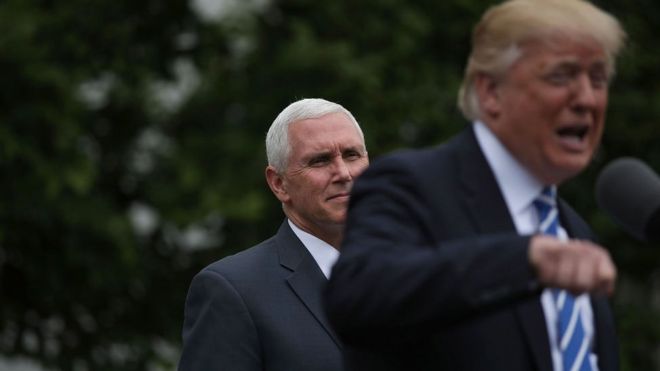 Mike Pence stands behind Donald Trump.