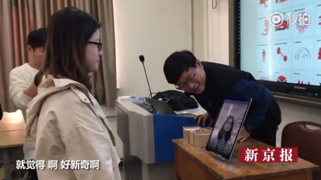 A Chinese student registering for her class using facial recognition