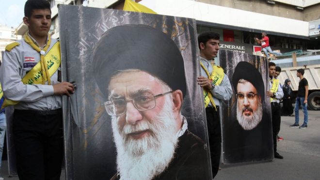 حامیان حزب‌الله لبنان درحال حمل تصاویر رهبر حزب‌الله و رهبر ایران