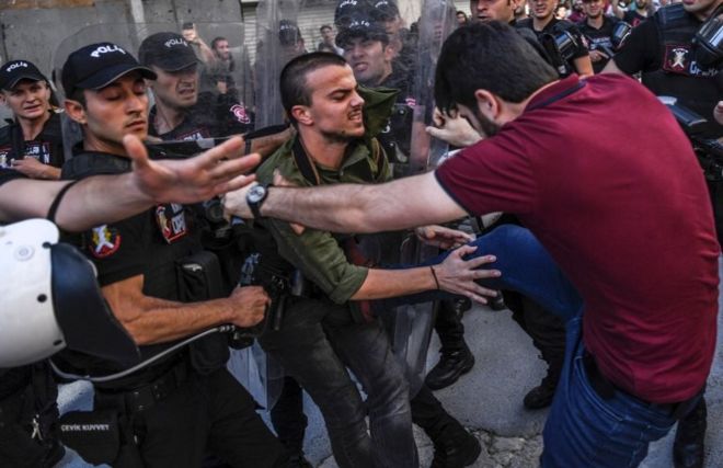 AFP haber ajansı geçtiği bu fotoğrafında sivil giyimli bir polisin LGBTİ aktivistine tekme attığını belirtti.