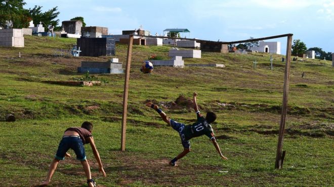 Crianças jogam futebol em cemitério em Rio Branco