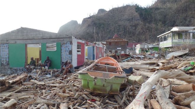 A boat can be seen lying amid rubble in Soufriere