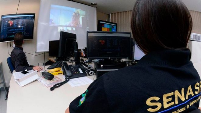 Brazilian police watch on a big screen as anti-paedophile raid unfolds