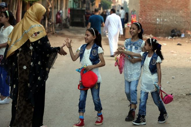 A group of girls is greeted by a woman during the Muslim holiday of Eid al-Fitr, in the village of Dalgamon, Tanta, some 120km north of Cairo, Egypt, 25 June